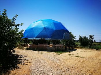 Built structure on field against clear blue sky