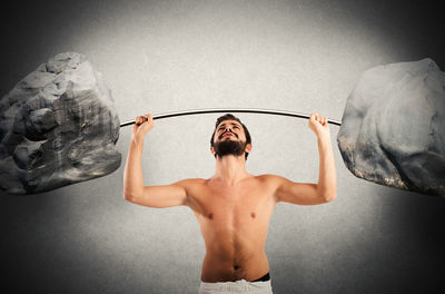 Full length of shirtless man standing against white background