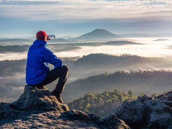 Man looking at mountains against sky