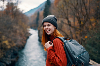 Portrait of young woman standing in forest during winter