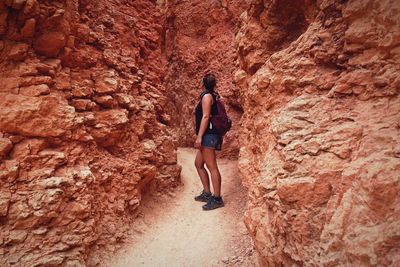 Rear view of woman standing on rock