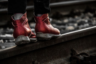 Low section of person standing by railroad track