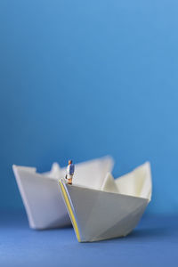 Close up of two origami paper ships with a miniature figure on it