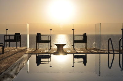 Scenic view of hotel pool on sea against sky during sunset