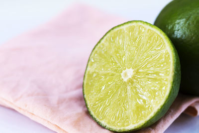 Close-up of lime with napkin against white background