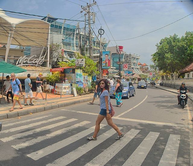 building exterior, street, full length, lifestyles, built structure, architecture, city, casual clothing, transportation, leisure activity, city life, road, walking, sky, car, sidewalk, day, city street