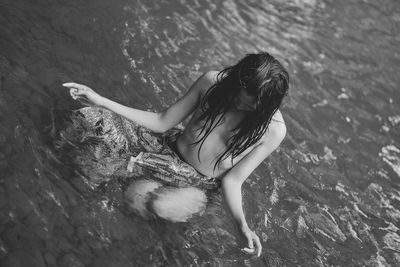 Rear view of young woman in water