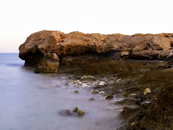 Rock formations by sea against sky