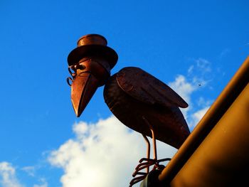 Low angle view of bird perching on blue sky