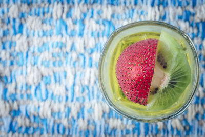 Directly above of kiwi and strawberry drink in glass on table