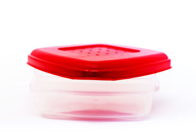Close-up of plastic container against white background
