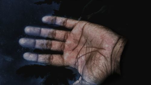 Close-up of human hand against black background