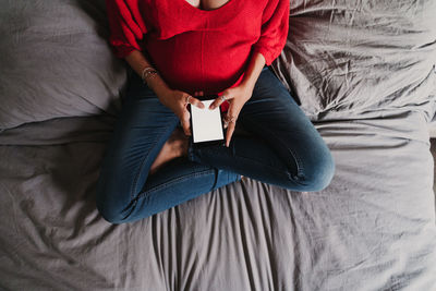 High angle view of woman relaxing on bed