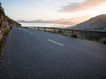 Road by mountains against sky