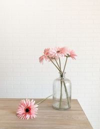 Flower vase on table against wall