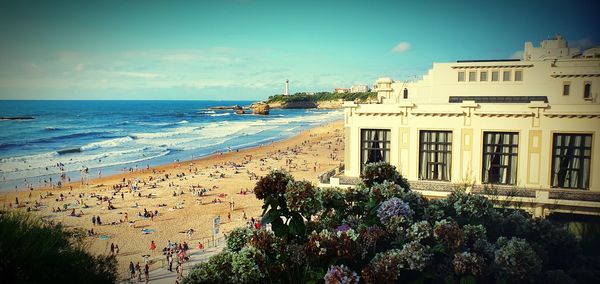 Scenic view of sea by buildings against sky