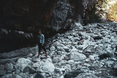 Portrait of young woman standing on rock