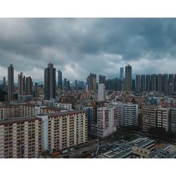 View of cityscape against cloudy sky