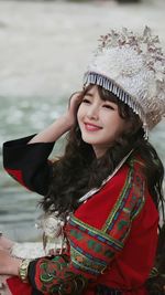 Portrait of young woman wearing hijab while standing against sea