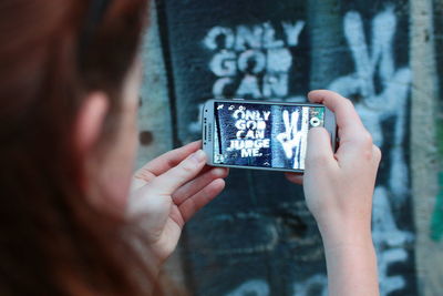 Cropped image of woman photographing through smart phone