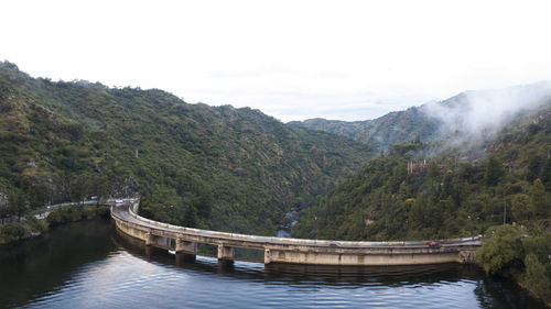 Scenic view of river amidst mountains against sky