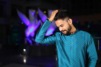 Young man in traditional clothing on stage at night