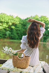 Rear view of woman sitting on table