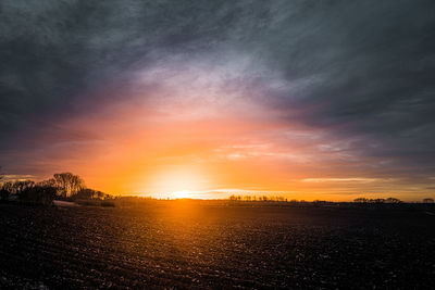 Scenic view of silhouette field against sky during sunset