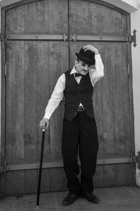 Full length portrait of man standing against door