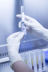 Cropped hands of scientist using syringe at laboratory