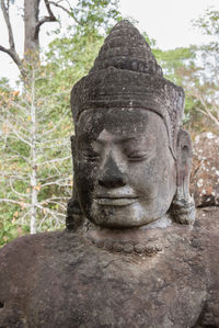 Close-up of buddha statue against trees