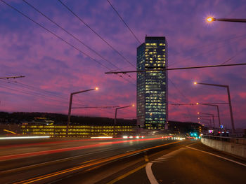 Light trails on road against sky at night