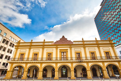 Low angle view of building against cloudy sky