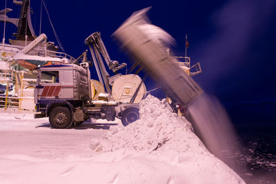 Truck dumping snow in lake