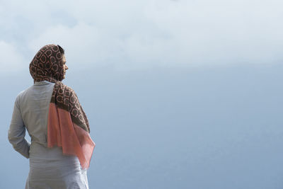 Rear view of woman standing against sky