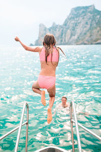 Rear view of woman walking in swimming pool