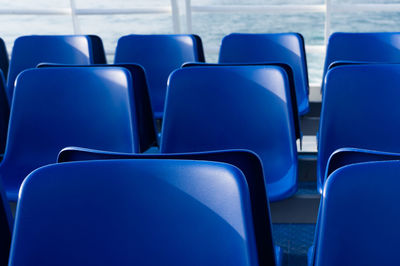 Rows of empty blue ferry boat seats