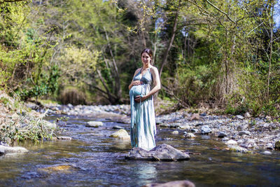 Portrait of woman standing by plants in lake