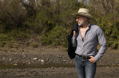 Adult man in cowboy hat in oasis of desert. almeria, spain