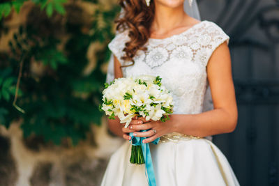 Midsection of woman holding flower bouquet