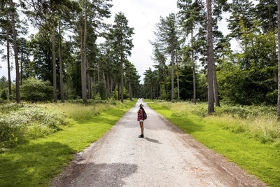 Woman standing on road in forest at cannock chase
