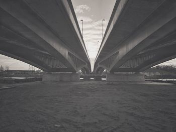 Bridge over river in city against sky