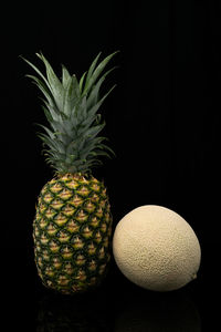 Close-up of fruits on table against black background
