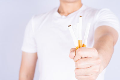 Midsection of man holding hands against white background