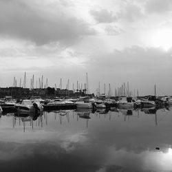 View of boats at marina against cloudy sky