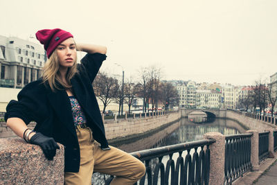 Portrait of young woman standing on wall