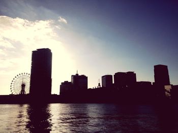 Silhouette cityscape against sky