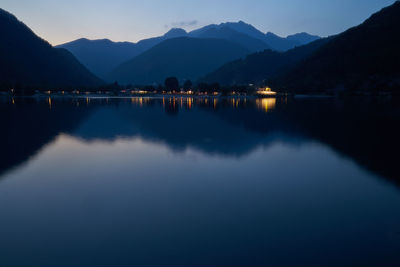 Scenic view of lake and mountains against blue sky