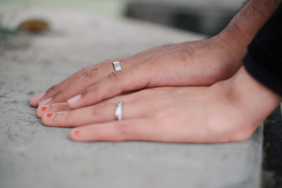 Holding hands with engagement ring on finger