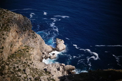 High angle view of rock formations by sea